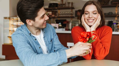 Photo of attractive man giving flowers to his beautiful woman, w