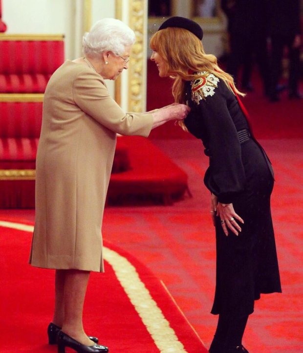 Королева Елизавета II вручает награду визажисту Шарлотт Тилбери