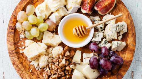 Cheese plate Assortment of various types of cheese on olive wood