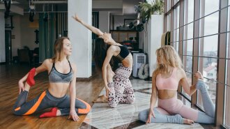 Young attractive women practicing yoga near window