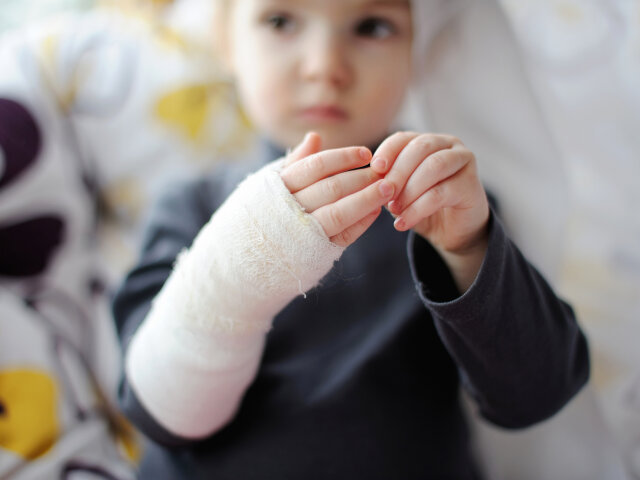 Little girl showing her hand bandaged