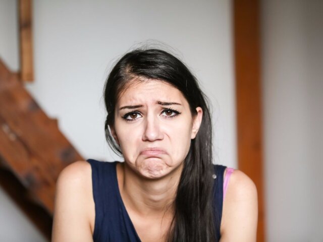 Beautiful brunette young woman with sad face. Sad expression, sa