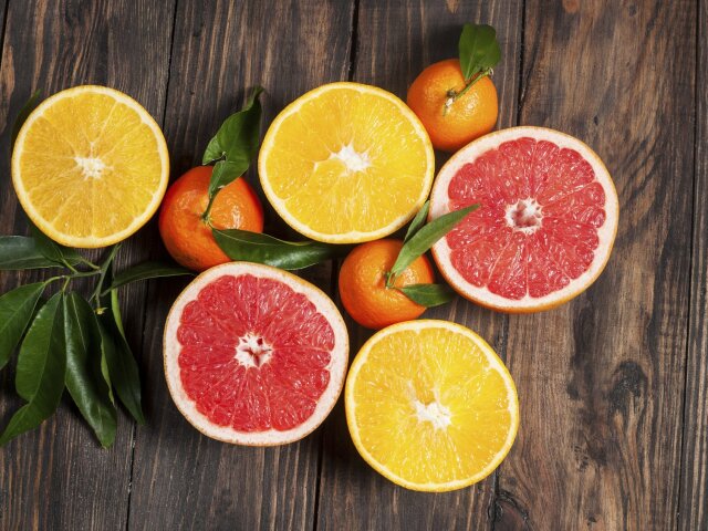 Citrus fruits. Over wooden table background