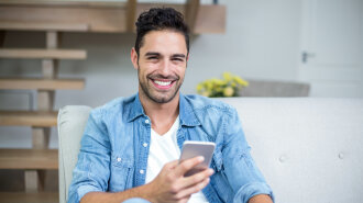 Smiling smart man using smartphone