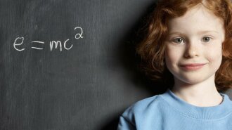 Girl-5-7-standing-by-formula-on-blackboard-smiling-portrait