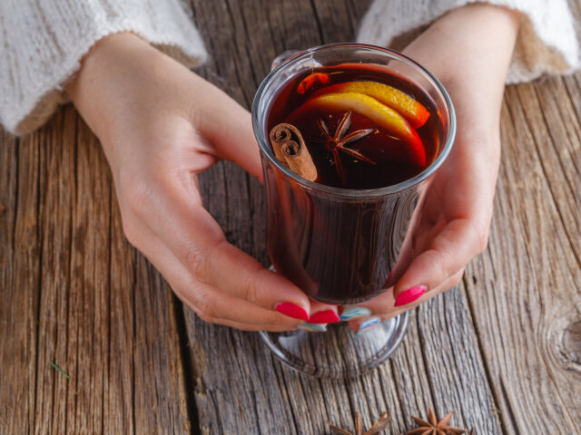 Mulled wine and spices on weathered wooden table