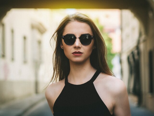 woman_looking_forward_in_sunglasses_and_a_black_halter_top