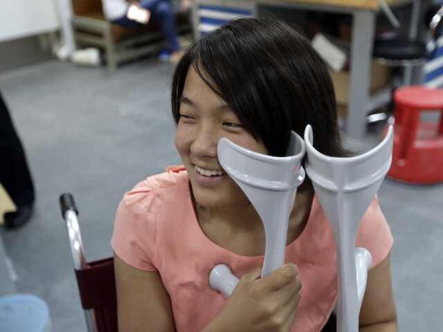 Qian Hongyan, 18, smiles as she waits for her new prosthesis at China Rehabilitation Centre in Beiji