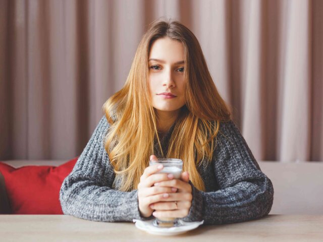 Romantic Girl in Knitted Sweater Enjoying a Cup of Hot Tea in Hands.