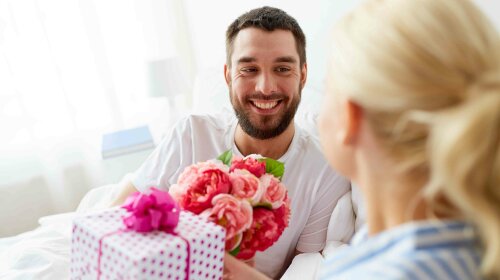 happy couple with gift box in bed at home