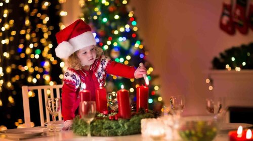 Little girl lighting candles at Christmas dinner