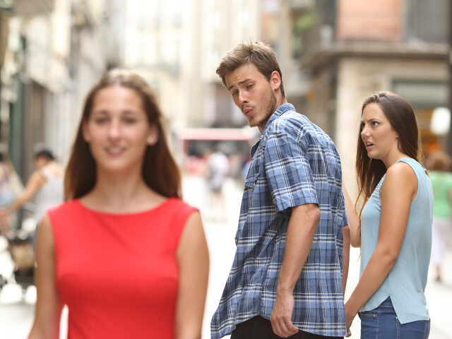 Disloyal man with his girlfriend looking at another girl