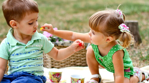 Caucasian little boy and girl eating sweets