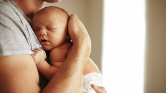 Tender moment between a father and newborn baby boy