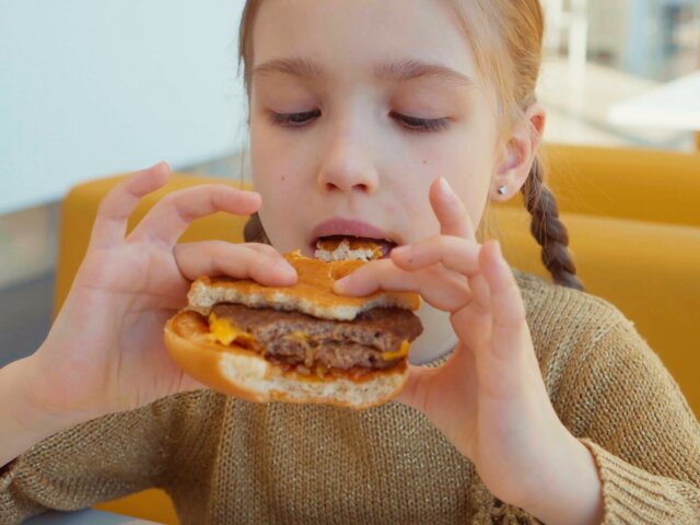 portrait-girl-eating-burger-in-the-fast-food_nlynyvecx__F0000