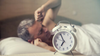 sleeping man disturbed by alarm clock early morning. Angry man i
