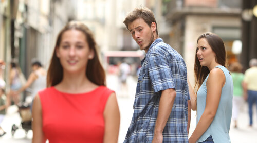Disloyal man with his girlfriend looking at another girl